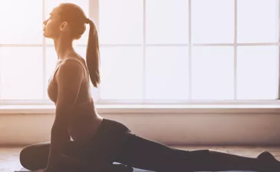 Junge Frau macht eine Yogaübung auf einer Gymnastikmatte