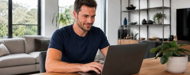Eine männliche sportliche Person sitzt an einem Laptop
