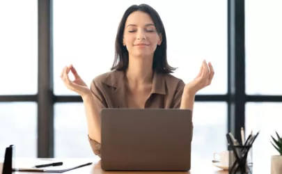 Frau meditiert im Büro und bewältigt Stress