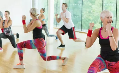 Aerobic Trainerin leitet Gruppe vor Spiegel an